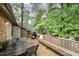 Spacious outdoor deck featuring wood flooring, a built-in bench, BBQ and lush greenery at 200 W Woodcroft Pkwy # 57B, Durham, NC 27713