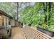 Spacious outdoor deck featuring wood flooring, a built-in bench, BBQ and lush greenery at 200 W Woodcroft Pkwy # 57B, Durham, NC 27713