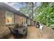Spacious outdoor deck featuring wood flooring, a dining table and a lush tree canopy at 200 W Woodcroft Pkwy # 57B, Durham, NC 27713