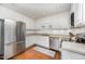 Updated kitchen with stainless steel appliances, white cabinets, hardwood floors, and a neutral countertop at 200 W Woodcroft Pkwy # 57B, Durham, NC 27713