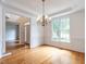 Formal dining room with beautiful hardwood floors, wainscoting, large windows, and a decorative chandelier at 203 Chilcott Ln, Apex, NC 27502