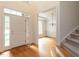 Bright and inviting foyer with gleaming hardwood floors, staircase access, and a view into the adjacent dining room at 203 Chilcott Ln, Apex, NC 27502