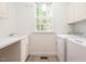 Bright laundry room featuring a washer, dryer, and sink with a window providing natural light at 203 Chilcott Ln, Apex, NC 27502