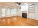 Spacious living room with hardwood floors, fireplace with built-ins, large windows, and access to the outdoor deck at 203 Chilcott Ln, Apex, NC 27502
