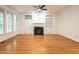 Bright living room featuring hardwood floors, a fireplace with built-in shelving, and large windows for plenty of natural light at 203 Chilcott Ln, Apex, NC 27502