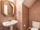 Cozy powder room featuring unique wallpaper, pedestal sink, gold-framed mirror, and classic fixtures at 203 Chilcott Ln, Apex, NC 27502