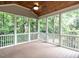 Spacious screened porch with wood flooring, a ceiling fan, and views of the lush backyard at 203 Chilcott Ln, Apex, NC 27502