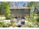 Rear exterior view of home featuring a large deck, lush greenery, and well-maintained landscaping at 203 Old Forest Creek Dr, Chapel Hill, NC 27514