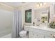 Bright bathroom with a shower-tub combo and a decorative tiled mirror at 203 Old Forest Creek Dr, Chapel Hill, NC 27514