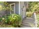 Charming front entrance with a covered porch, gray siding, and manicured landscaping at 203 Old Forest Creek Dr, Chapel Hill, NC 27514