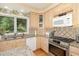 The kitchen has stainless appliances, granite countertops, and a cozy window view of surrounding greenery at 203 Old Forest Creek Dr, Chapel Hill, NC 27514
