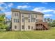 Well-maintained back exterior of a three-story home featuring a wooden deck overlooking a manicured lawn at 208 Bridle Boast Rd, Cary, NC 27519