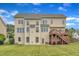 Expansive back exterior of this three-story home with a wooden deck and a well-maintained lawn at 208 Bridle Boast Rd, Cary, NC 27519