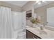 Bathroom featuring a marble vanity top, bathtub, shower with white curtain, and decorative plants and artwork at 208 Bridle Boast Rd, Cary, NC 27519