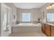 Large soaking tub with tile surround, a privacy window, and adjacent vanity and sink at 208 Bridle Boast Rd, Cary, NC 27519