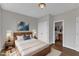 A bedroom with a wooden bed, ensuite bathroom and a large painting on the wall at 208 Bridle Boast Rd, Cary, NC 27519