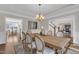 Light-filled dining room featuring hardwood floors, a wooden table with seating for six and modern lighting at 208 Bridle Boast Rd, Cary, NC 27519