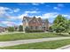 Charming brick and siding home with a well-maintained lawn and mature landscaping on a sunny, blue-sky day at 208 Bridle Boast Rd, Cary, NC 27519