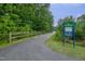 Paved community greenway trail featuring mature trees and marked with a trail map sign at 208 Bridle Boast Rd, Cary, NC 27519
