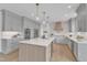 Bright kitchen with gray cabinets, oversized island with light wood accents, and stainless appliances at 208 Bridle Boast Rd, Cary, NC 27519