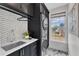 Modern laundry room featuring dark cabinets, stainless steel appliances and a window with natural light at 208 Bridle Boast Rd, Cary, NC 27519