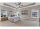 Bright main bedroom featuring neutral walls and carpeting, and three large windows overlooking the landscaped property at 208 Bridle Boast Rd, Cary, NC 27519