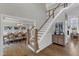 Beautiful staircase view with adjacent dining room, featuring pristine hardwood floors at 208 Bridle Boast Rd, Cary, NC 27519