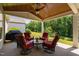 Covered patio with ceiling fan, wooden ceiling, BBQ grill, and four comfortable chairs at 211 Ibis Ln, Durham, NC 27703