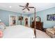 A spacious bedroom featuring a four-poster bed, a ceiling fan, and serene blue walls at 211 Ibis Ln, Durham, NC 27703