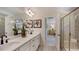 Bathroom with double sinks, large mirror, decorative lighting, and a glass enclosed shower with a seat at 215 Blue Butterfly Dr, Angier, NC 27501