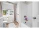 Bathroom featuring white tub/shower combo, toilet and window view at 220 Purslane Dr, Franklinton, NC 27525