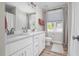 Bright bathroom featuring double sinks, white cabinets, tile flooring, blinds and modern fixtures at 220 Purslane Dr, Franklinton, NC 27525