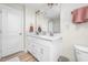 Bathroom featuring double sinks, a toilet, a shower over the tub with laminate flooring at 220 Purslane Dr, Franklinton, NC 27525