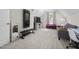 A spacious bonus room features carpet, with a workout machine, gray sofa, and natural light at 220 Purslane Dr, Franklinton, NC 27525