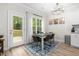 Bright dining room featuring light hardwood flooring, a modern chandelier, and access to the outdoor deck at 220 Purslane Dr, Franklinton, NC 27525