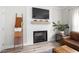 Living room fireplace featuring a modern white mantel, a large tv, and light hardwood flooring at 220 Purslane Dr, Franklinton, NC 27525