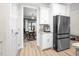 Open kitchen with stainless steel refrigerator, white cabinets, and an adjacent home office at 220 Purslane Dr, Franklinton, NC 27525