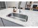 Close up of a stainless kitchen island sink with white granite countertop and seating at the island at 220 Purslane Dr, Franklinton, NC 27525