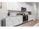 Modern kitchen with white cabinetry, granite countertops, and stainless steel appliances at 220 Purslane Dr, Franklinton, NC 27525