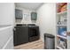 Well-organized laundry room featuring front-load washer/dryer, cabinets and laminate flooring at 220 Purslane Dr, Franklinton, NC 27525