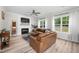 Comfortable living room with a fireplace, a ceiling fan, and large windows providing natural light at 220 Purslane Dr, Franklinton, NC 27525