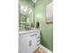Powder room with a white vanity, decorative mirror, and sage-green walls at 220 Purslane Dr, Franklinton, NC 27525
