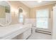 Bright bathroom featuring double sinks, vanity, and neutral tiling at 2228 Walker Ave, Burlington, NC 27215
