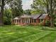 Charming brick home with a manicured lawn, mature trees and black shutters exudes curb appeal at 2228 Walker Ave, Burlington, NC 27215
