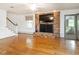 Bright living room with brick fireplace, mounted TV, beautiful hardwood floors, and natural light at 2228 Walker Ave, Burlington, NC 27215