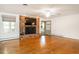 Bright living room with brick fireplace, mounted TV, beautiful hardwood floors, and natural light at 2228 Walker Ave, Burlington, NC 27215