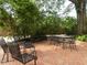 Charming brick patio surrounded by lush greenery, perfect for outdoor dining and relaxation at 2228 Walker Ave, Burlington, NC 27215