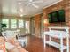 Well-lit sunroom with brick wall, ample seating, and multiple windows for relaxing at 2228 Walker Ave, Burlington, NC 27215