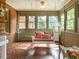 Cozy sunroom with a swing, brick flooring, and plenty of natural light at 2228 Walker Ave, Burlington, NC 27215