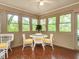 Bright sunroom with seating around a table, surrounded by windows and greenery at 2228 Walker Ave, Burlington, NC 27215